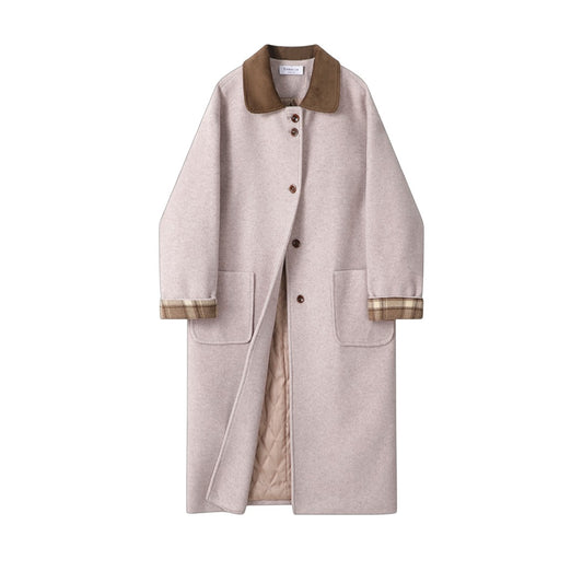 アシンメトリーな襟元と切り替えデザインがわかる、ヴィンテージデザイン ロングコートの正面アップ画像。