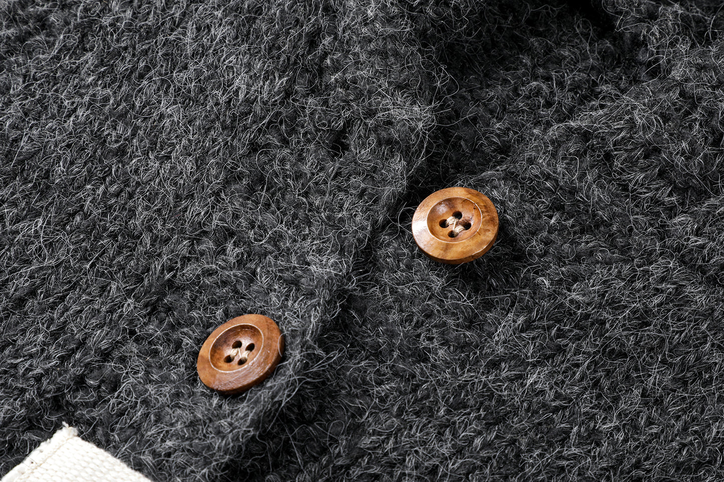 フーディーニットカーディガンの上質なニット生地のテクスチャとボタンの拡大画像。