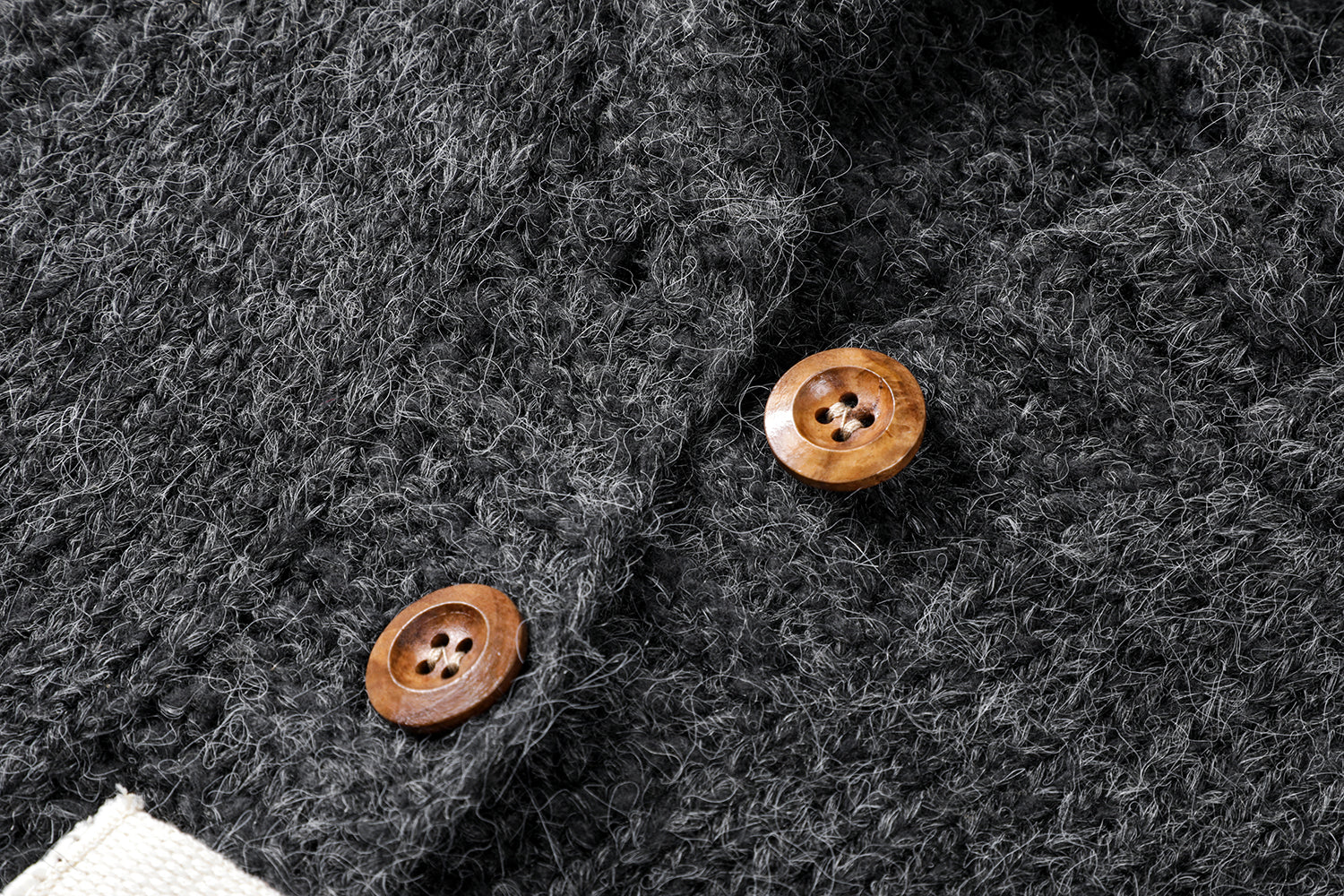 フーディーニットカーディガンの上質なニット生地のテクスチャとボタンの拡大画像。