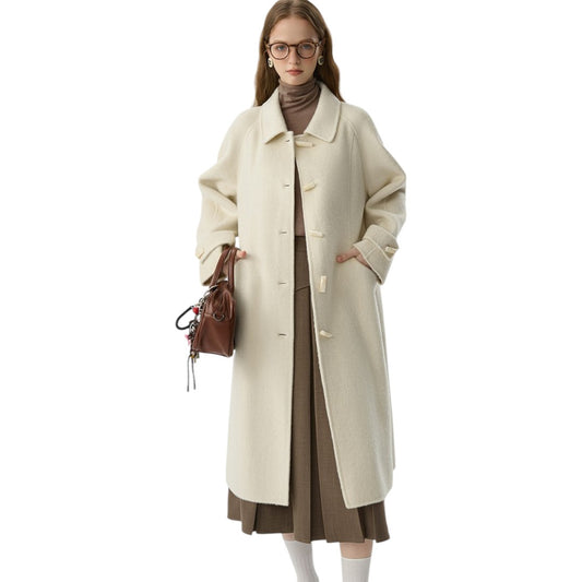 アプリコットカラーのレトロなダブルフェイスウールコートを着た20代女性。大きなラペルとホーンボタンが特徴的な冬のきれいめコーデ。