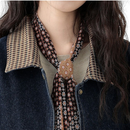 チェック柄の襟とデニムの切り替えが特徴的なデニムジャケットの正面アップ。シルバーのボタンディテール。