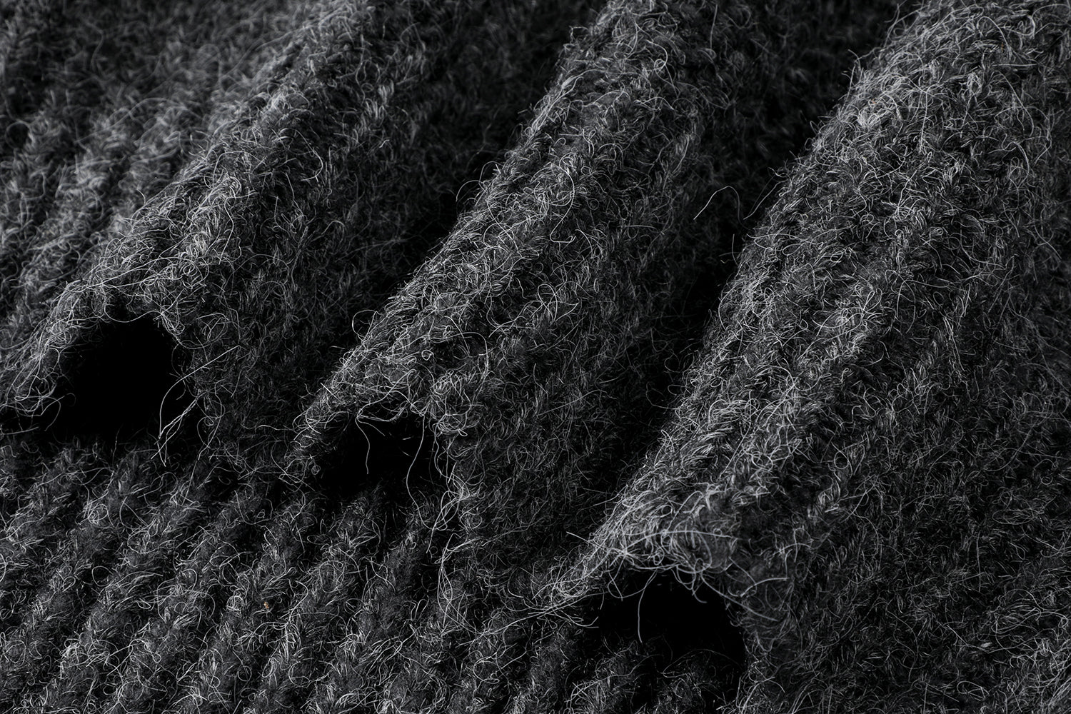 フーディーニットカーディガンの上質なニット生地のテクスチャとボタンの拡大画像。