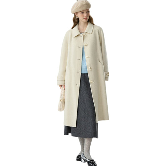 アプリコットカラーのレトロなダブルフェイスウールコートを着た20代女性。大きなラペルとホーンボタンが特徴的な冬のきれいめコーデ。