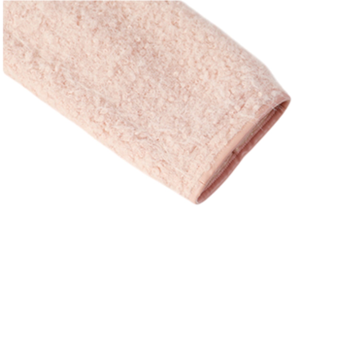 ツイードジャケットのゴールドボタンとブークレ生地のテクスチャを写した拡大写真。